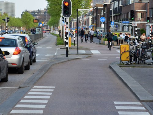 Ein Radweg ändert in der Höhe mit sanfte Übergang, an Kreuzung mit Verkehrsampel