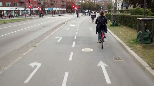 Leuten fahr mit dem Rad auf eine ebene, breite Radweg in Kopenhagen.